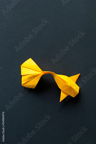Handmade paper craft origami gold koi carp fish on black background.Top view