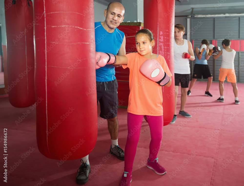 Girl teenager at boxing workout on punching bag
