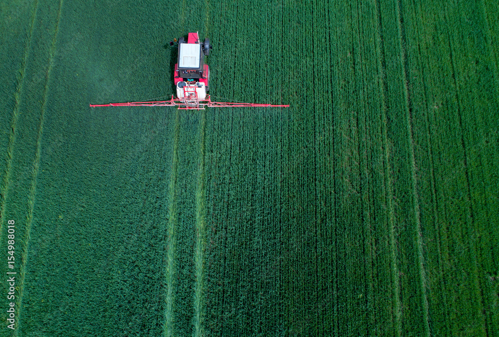 Naklejka premium Tractor spraying field