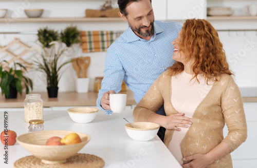 Adorable shot of husband talking to pregnant wife photo