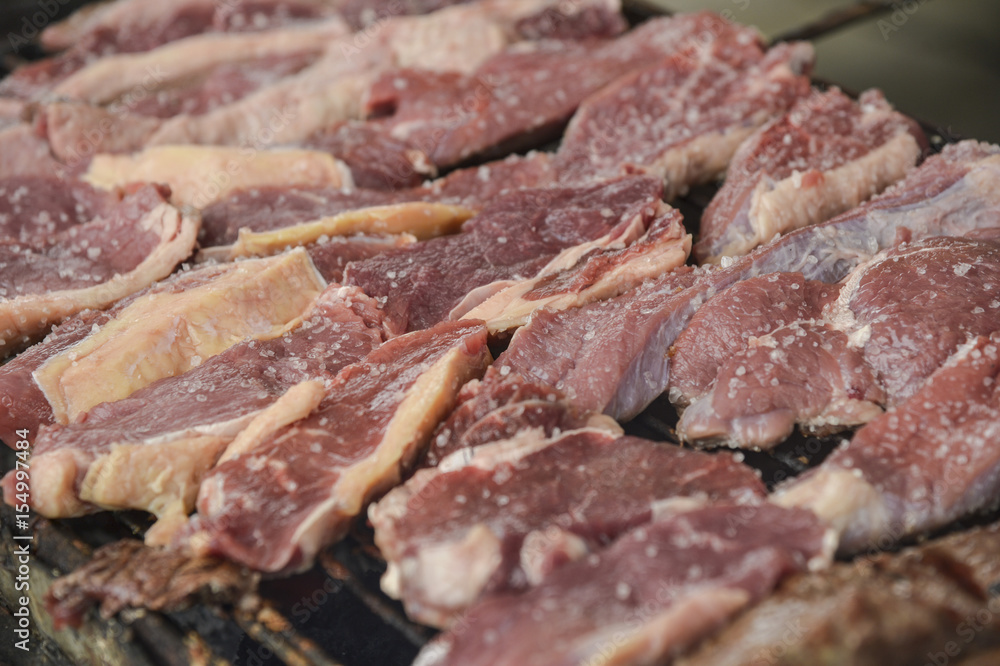 Beef (red) that has just been placed on the barbecue Beef (red) that has just been placed on the barbecue