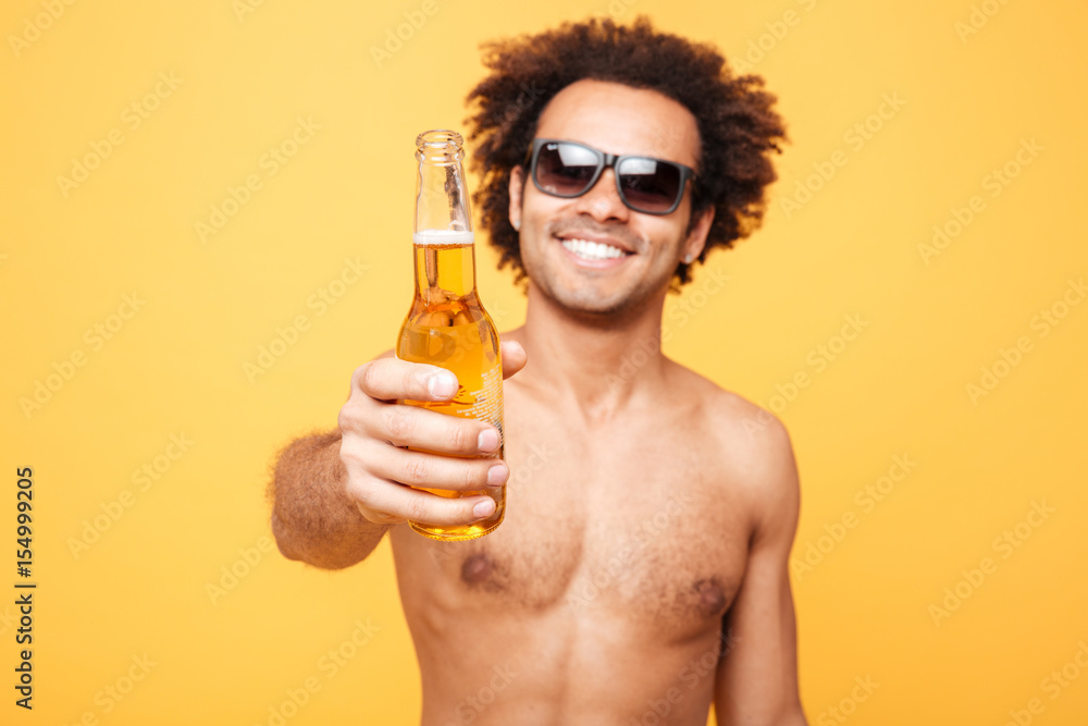 Portrait of a african man in sunglasses showing beer bottle Portrait of a african man in sunglasses showing beer bottle