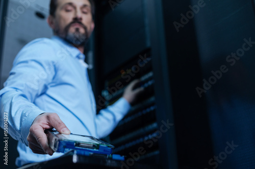 Handsome bearded programmer taking a rack server