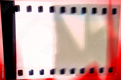 Vintage film strip frame on old and damaged paper background.