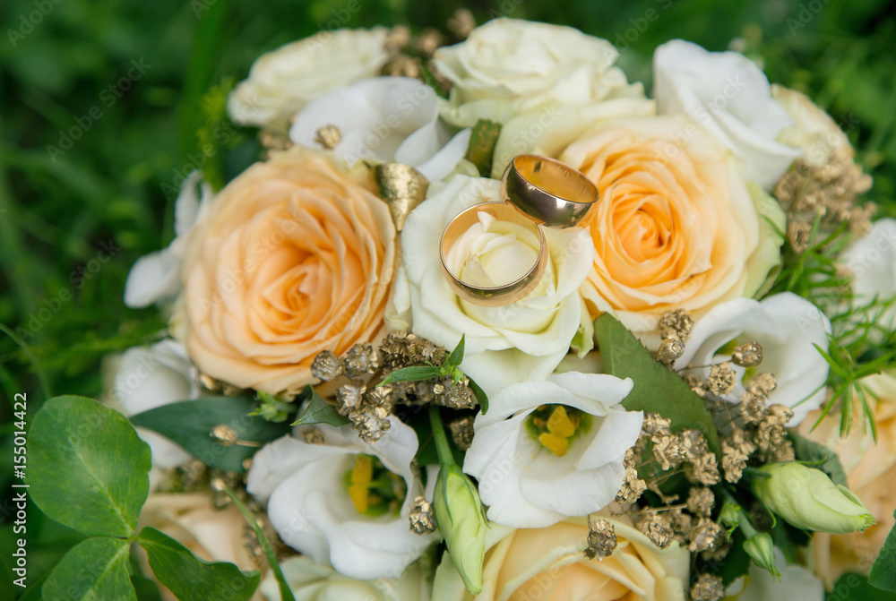 Obraz premium Wedding rings on wedding bouquet bride