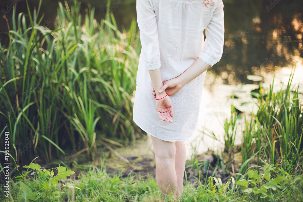 Fototapeta premium A girl in a white shirt is standing with her back
