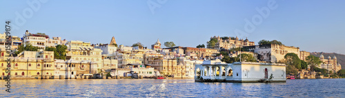 Panoramic view of buildings on water and City Palace in Udaipur in India. View from Pichola Lake