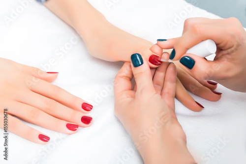Girl has a manicure and paint nails with lacquer in the beauty salon
