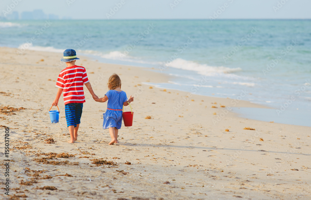 little boy and girl walking on beach little boy and girl walking on beach