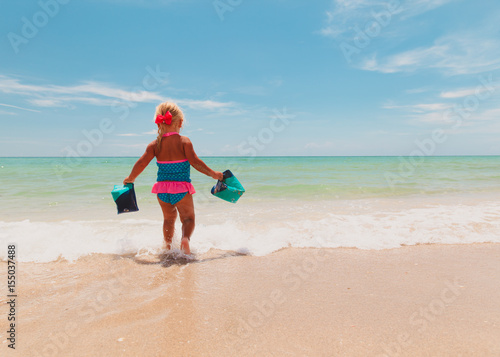 little girl going to swim at beach