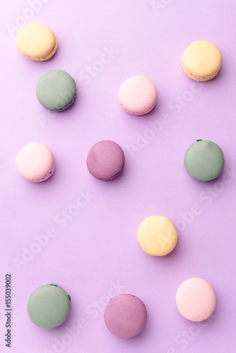 Sweet colorful macaroons on purple table background.
