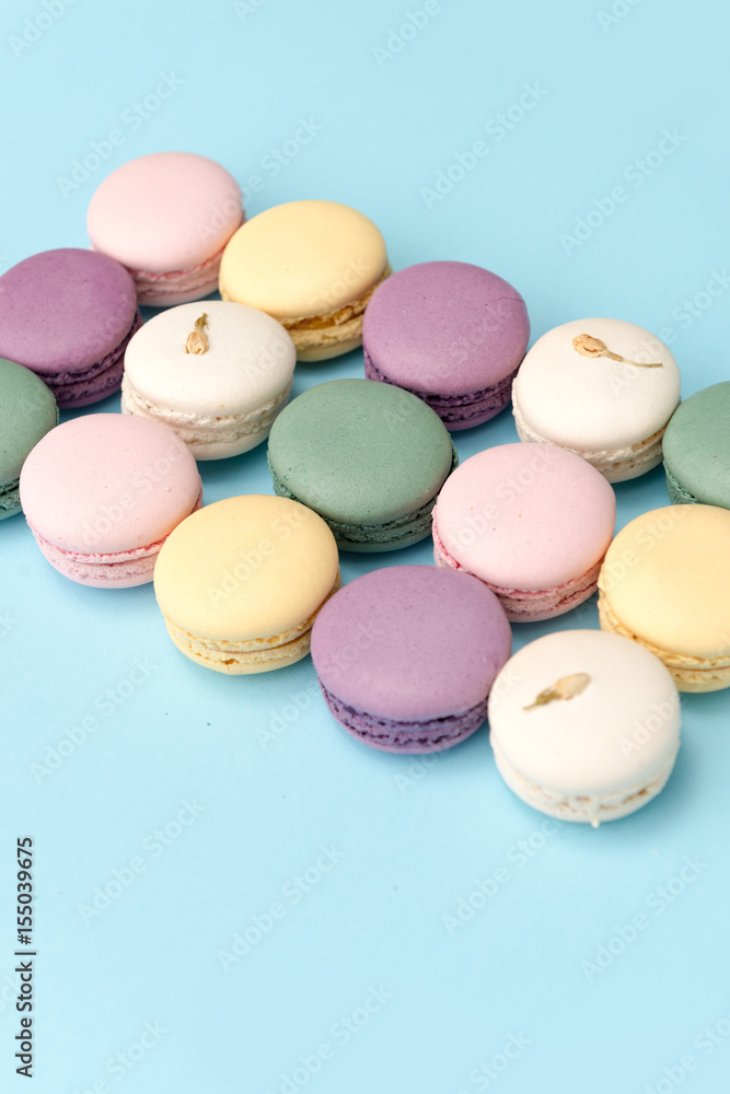 Sweet colorful macaroons on blue table background.