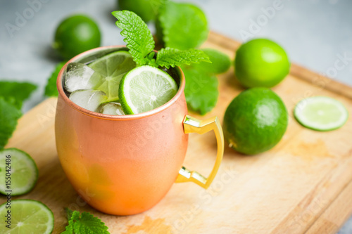 Cold Moscow Mule cocktail in copper mug on the rustic background. Shallow depth of field.