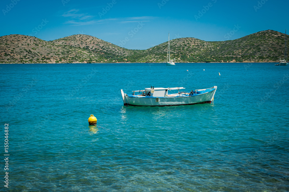 Boat on the turquoise water, Greece, Crete, island behind
