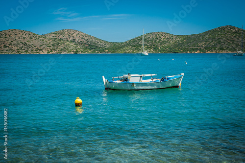 Obraz na płótnie Boat on the turquoise water, Greece, Crete, island behind w salonie