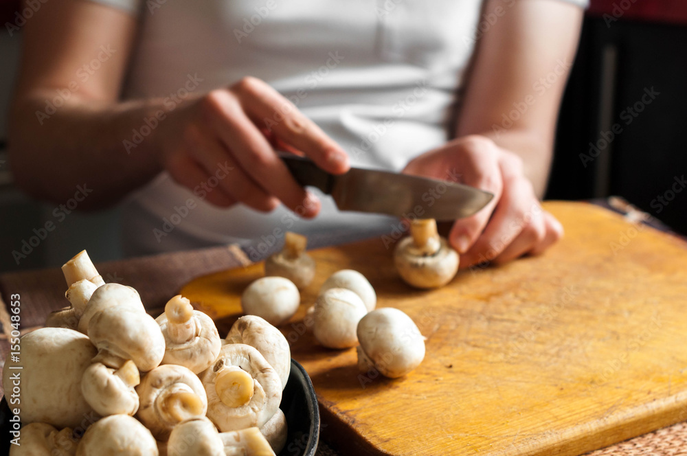 man cutting mushrooms on wooden cutting board man cutting mushrooms on wooden cutting board