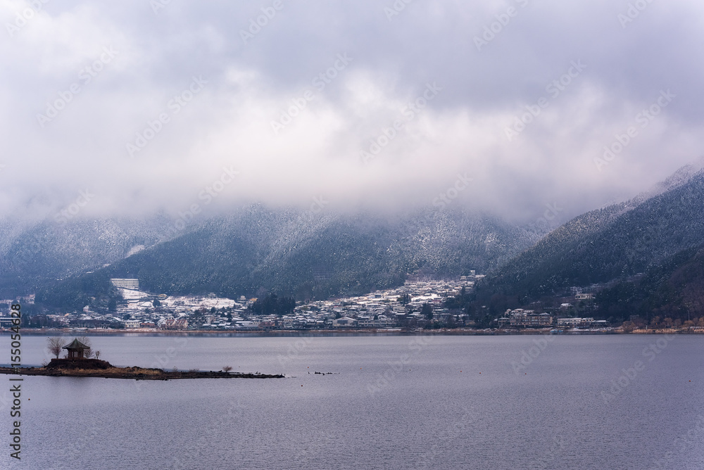 Mountain in low lying cloud and snow with the village shrouded in mist a scenic landscape view at Japan. travel Winter landscape in japan.