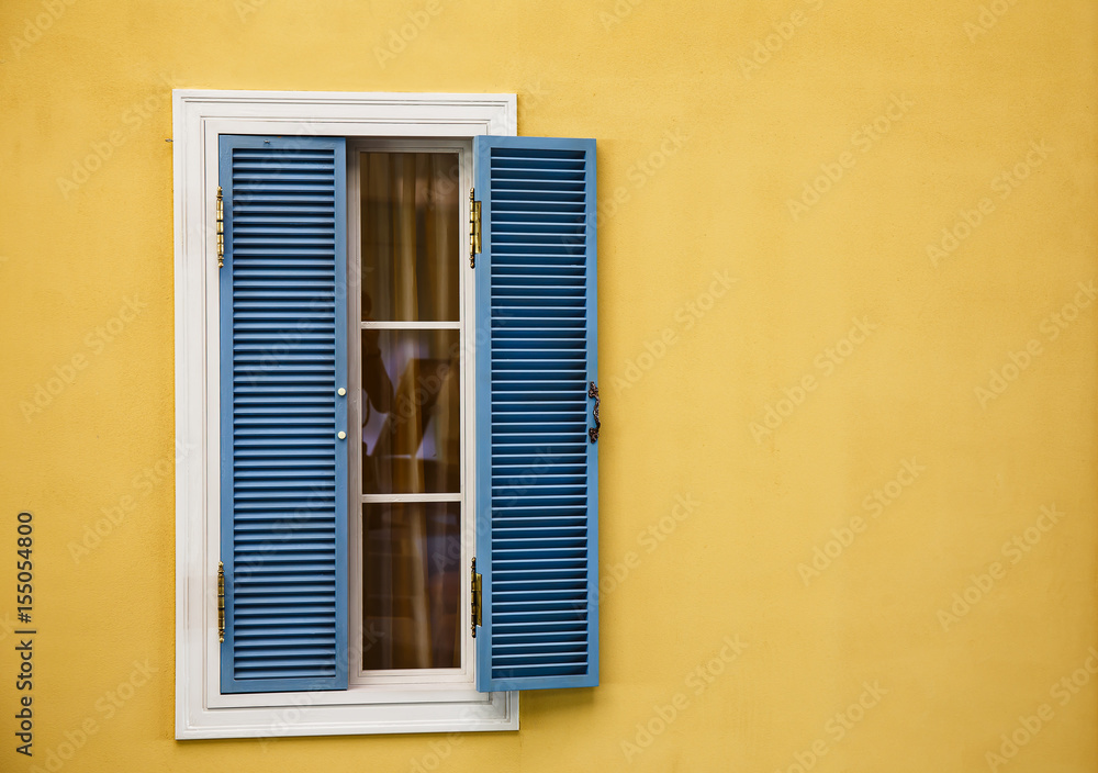 Wooden windows on yellow walls