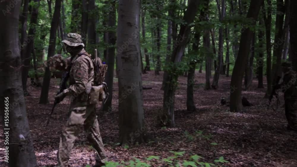 Guerilla partisan warriors attacking aiming in forest ambush carrying their guns. War battlefield maneuvers training. Guerilla partisan warriors attacking aiming in forest ambush carrying their guns. War battlefield maneuvers training.