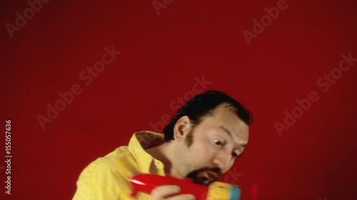 A grownup man starting the engine of a toy plane and flying away with it. Funny scene.
 photo