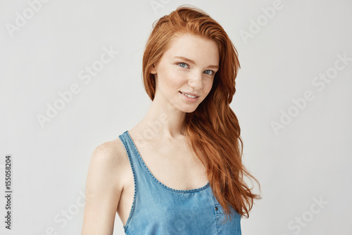 Portrait of beautiful ginger girl smiling looking at camera.