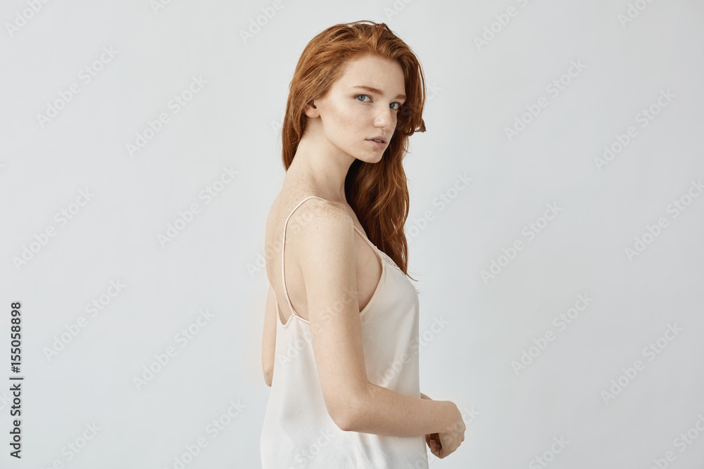 Beautiful redhead model in sleepwear posing looking at camera. Beautiful redhead model in sleepwear posing looking at camera.