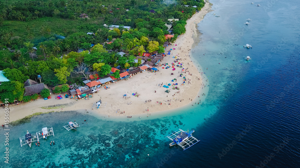 Fototapeta premium Aerial view of sandy beach with tourists swimming in beautiful clear sea water of the Sumilon island beach landing near Oslob, Cebu, Philippines. - Boost up color Processing.
