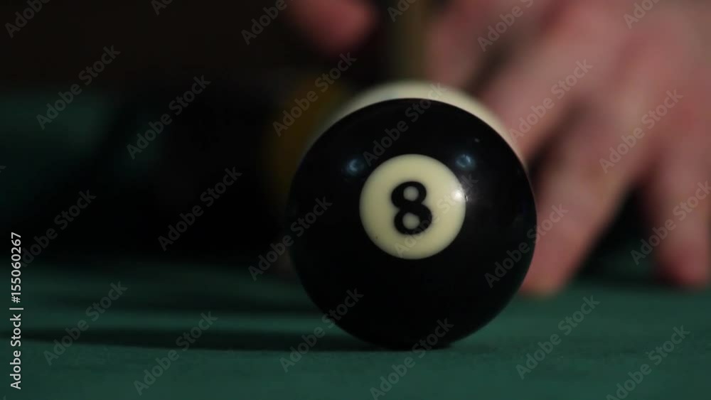 Billiard player hitting cue ball and white ball hit black ball. Black