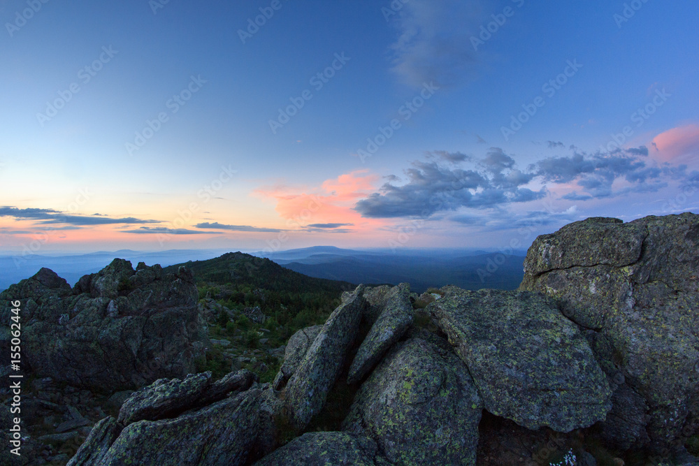 Sunset over the mountainous terrain. The nature of the Southern Urals. Sunset sky over the forest and the mountains.