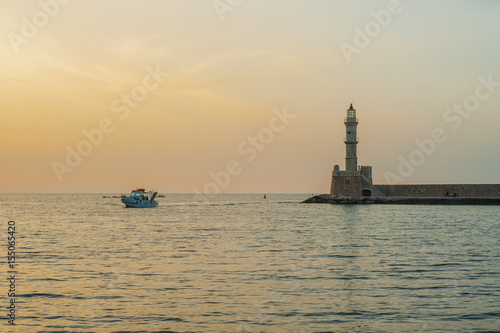 Greece, Crete, sunset in Chania (Xania) evening light to city. Boat sun and light house view