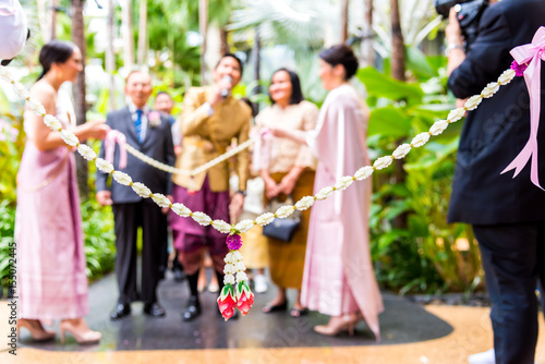 Bridesmaids Holding Garland Jasmine at the Opening Ceremony of Thai Wedding
with groom is negotiating to find the bride.