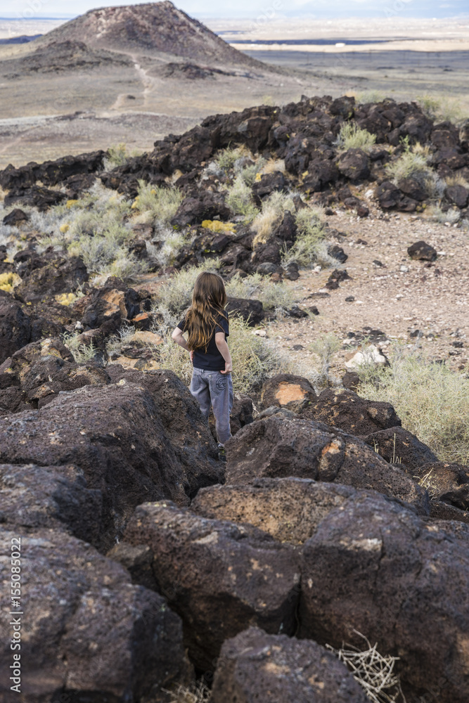 boy exploring an ancient volcano in the desert 