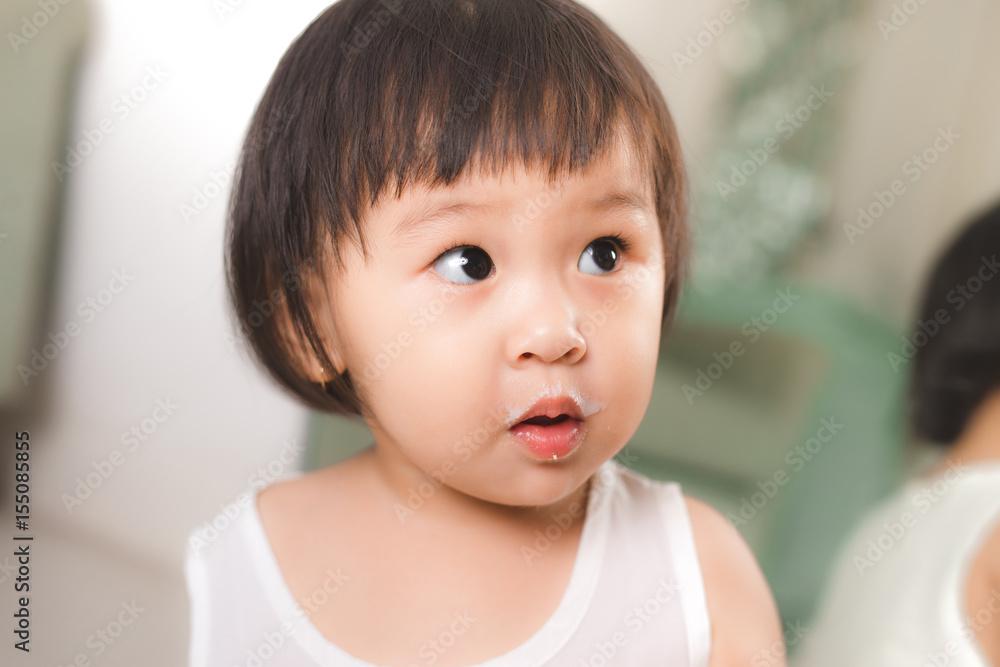 Cute baby girl with milk mustache at home Cute baby girl with milk mustache at home