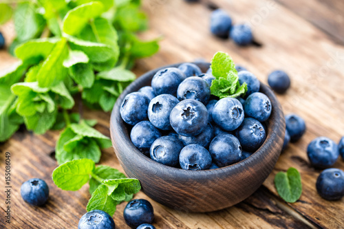 Fresh blueberries in bowl on wooden table