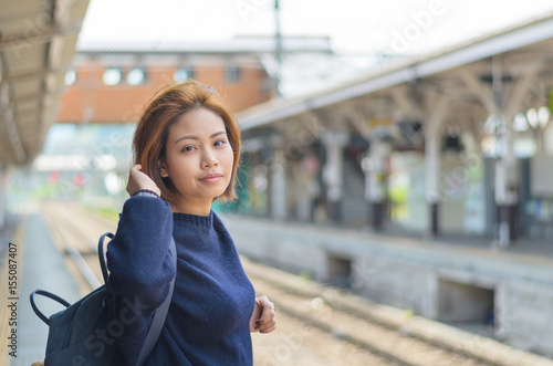 Female traveler waiting for train at outdoor train station in japan
