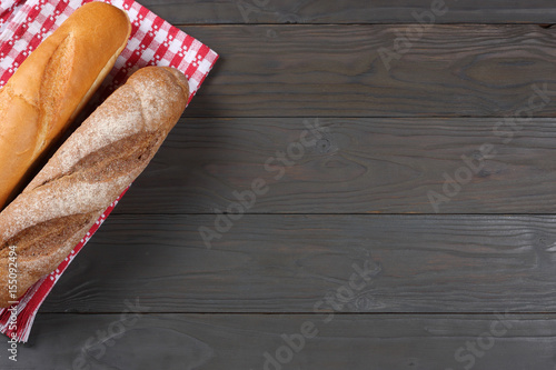 freshly baked bread on dark wooden background with red cloth. With copy space. Top view.