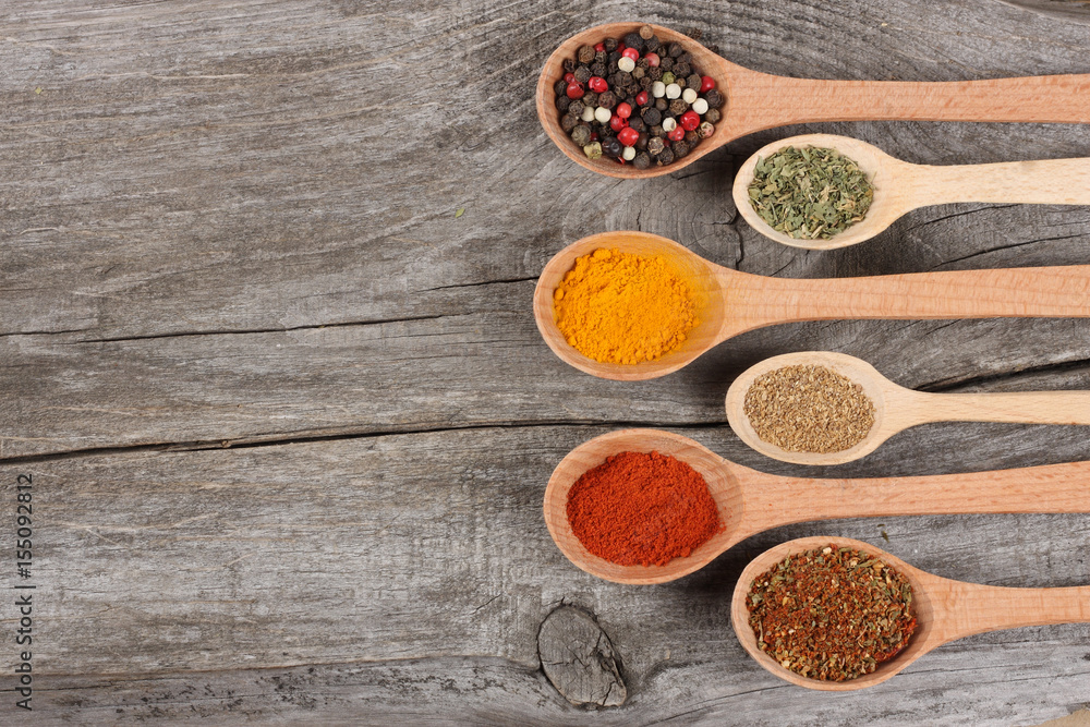 spices in spoon on old wood background spices in spoon on old wood background