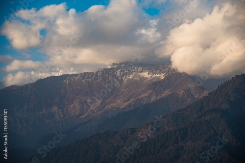 Morning view of snow-capped mountains with clouds drifting over the peaks in a scenic alpine landscape
