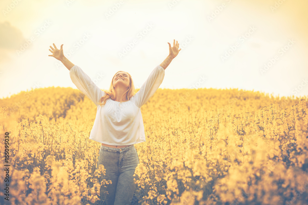 Happy smiling woman in yellow rapeseed field at sunset freedom concept Happy smiling woman in yellow rapeseed field at sunset freedom concept