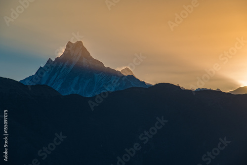 Sunrise over the snowy mountains with a panoramic view of the valley and foggy sky