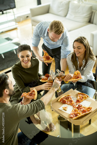Young people eating pizza a...