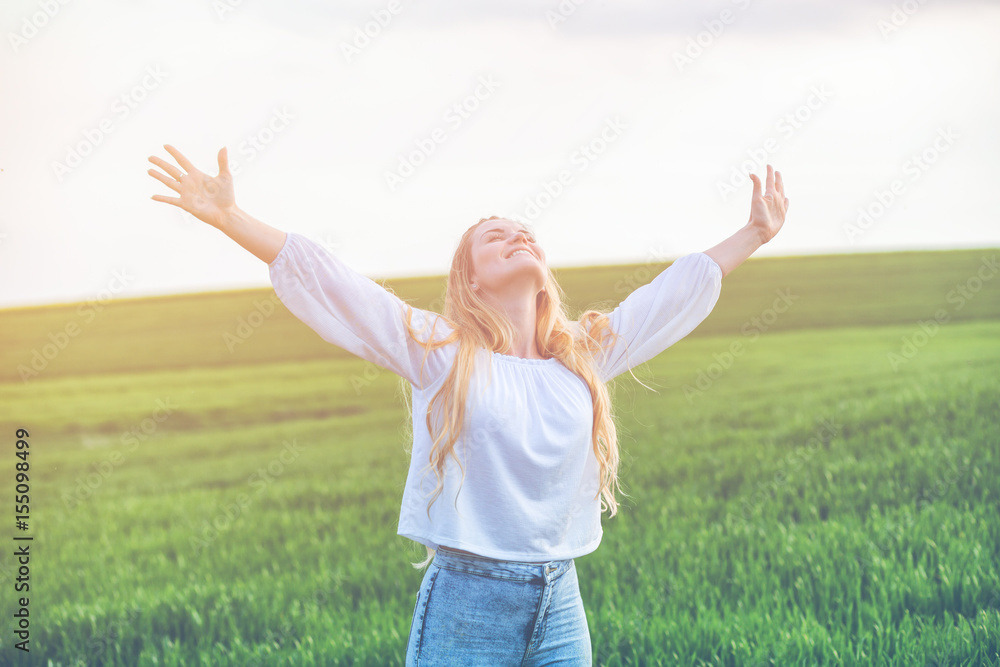 Happy smiling woman in green field at summer day freedom concept Happy smiling woman in green field at summer day freedom concept