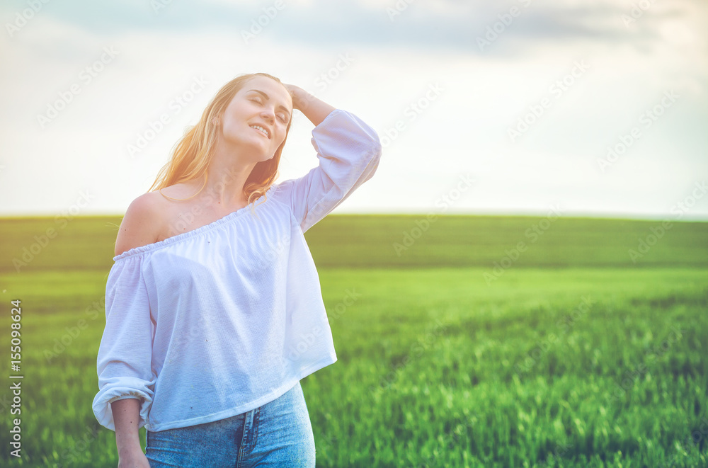 Happy smiling woman in green field at sunny day Happy smiling woman in green field at sunny day