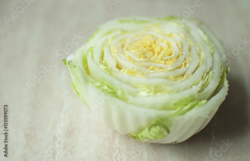 Cut Chinese cabbage stalk on a wooden table. Top view © danshanin