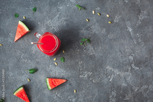 Watermelon juice and watermelon slices on black background. Summer concept. Top view, flat lay