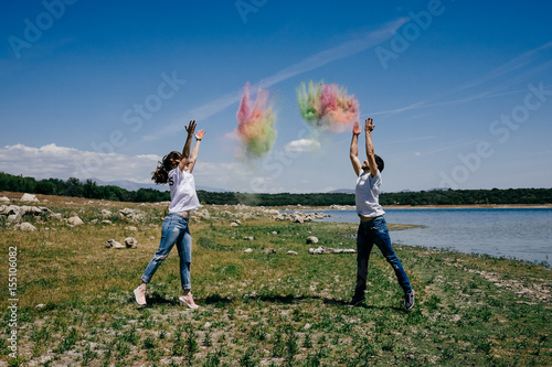 Lovely couple having fun outdoors playing with colorful holi powder. Lifestyle portrait