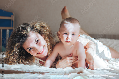 mother and baby lie on bed photo