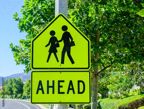 Students cross the road near with trees in background
