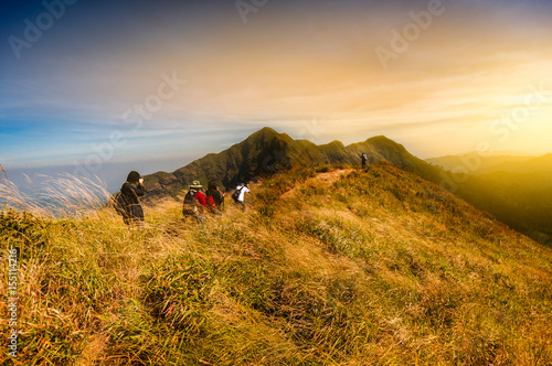 Group of tourist enjoy hiking on the top of mountain with amazing scenic of changpuek mountain in Kanchanaburi, Thailand; Gold light filtered