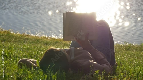 Reading a book on a lawn in the park